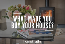 A flower vase and magazine above a table with a modern fireplace in a background